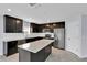 Modern kitchen features dark cabinets, stainless steel appliances, a large island, and white countertops at 4492 Bluff Oak Loop, Kissimmee, FL 34746