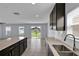 Well-lit kitchen overlooks the living area, featuring white countertops and dark cabinets at 4492 Bluff Oak Loop, Kissimmee, FL 34746