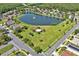Aerial view of a tranquil community pond with a fountain, lush greenery, and walking trails at 4492 Bluff Oak Loop, Kissimmee, FL 34746