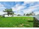 Large backyard with a privacy fence, green grass, and mature trees at 4613 Madison Ave, Lake Wales, FL 33859