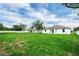 Wide backyard featuring lush green grass, a white fence, and views of the house's exterior at 4613 Madison Ave, Lake Wales, FL 33859