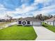 Charming single-story home with a well-manicured lawn, long driveway and attached garage at 4613 Madison Ave, Lake Wales, FL 33859