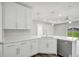 A modern kitchen features white cabinets, quartz countertops, and stainless steel appliances at 4613 Madison Ave, Lake Wales, FL 33859