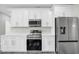A modern kitchen features white cabinets, quartz countertops, and stainless steel appliances at 4613 Madison Ave, Lake Wales, FL 33859