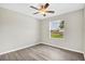 This bedroom features stylish gray flooring and a ceiling fan with a light fixture at 4615 Madison Ave, Lake Wales, FL 33859