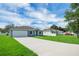The front of the house showcasing a long driveway with green lawn space, and a blue sky at 4615 Madison Ave, Lake Wales, FL 33859