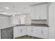 Well-lit kitchen features granite countertops, white cabinets, and stainless steel dishwasher at 4615 Madison Ave, Lake Wales, FL 33859