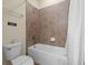 Bathroom with tiled shower and bathtub combination, toilet, and wall signage at 551 Lasso Dr, Kissimmee, FL 34747