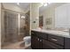 Well-lit bathroom featuring granite counters, a glass-enclosed shower, and brown tile at 551 Lasso Dr, Kissimmee, FL 34747