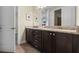 Bathroom featuring a double sink vanity with dark wood cabinets and light granite countertops at 551 Lasso Dr, Kissimmee, FL 34747