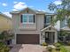 Two-story home with brown shutters, a brick driveway and a two-car garage at 551 Lasso Dr, Kissimmee, FL 34747
