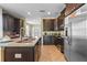 Spacious kitchen with stainless steel appliances, a large island, and dark wood cabinets at 551 Lasso Dr, Kissimmee, FL 34747
