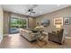 Cozy living room with neutral tones, a large sectional sofa, and access to the pool area at 551 Lasso Dr, Kissimmee, FL 34747