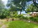 Large, grassy backyard with a ladder and various trees, bushes, and landscaping features at 6478 Inca St, Orlando, FL 32807