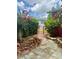 Landscaped backyard featuring a vibrant garden, a stone patio, and a charming gate at 6478 Inca St, Orlando, FL 32807