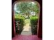View of the neighborhood street from the home's doorway with a sidewalk lined with manicured bushes at 6478 Inca St, Orlando, FL 32807