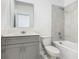 Well-lit bathroom featuring gray vanity, toilet and shower-tub with gray tiling at 7685 Stone Creek Trl, Kissimmee, FL 34747