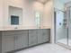 Bathroom featuring double vanity with gray cabinets, quartz countertop, and glass shower at 7685 Stone Creek Trl, Kissimmee, FL 34747