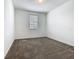 Cozy bedroom with neutral carpet, a window offering natural light, and fresh, white walls at 7685 Stone Creek Trl, Kissimmee, FL 34747