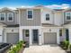 Charming townhome featuring a gray two-car garage, complemented by well-maintained landscaping at 7685 Stone Creek Trl, Kissimmee, FL 34747