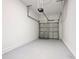 Empty one car garage with gray painted floors and metal door at 7685 Stone Creek Trl, Kissimmee, FL 34747
