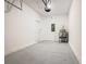 Empty one car garage featuring gray painted floors, door to the house, and water heater at 7685 Stone Creek Trl, Kissimmee, FL 34747