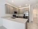 Kitchen with stainless steel appliances, gray cabinets, and quartz countertops at 7685 Stone Creek Trl, Kissimmee, FL 34747