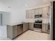 Modern kitchen featuring stainless steel appliances, grey cabinets, and a center island at 7685 Stone Creek Trl, Kissimmee, FL 34747