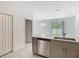 Open-concept kitchen with stainless steel appliances and tile floors, adjacent to the living area at 7685 Stone Creek Trl, Kissimmee, FL 34747