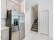 Kitchen with stainless steel refrigerator, gray cabinets, and view of the staircase at 7685 Stone Creek Trl, Kissimmee, FL 34747