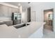 Kitchen featuring stainless appliances, grey cabinets, island with sink, and bathroom access at 7685 Stone Creek Trl, Kissimmee, FL 34747