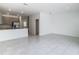 Spacious, open-plan living area with kitchen view and ceramic tile flooring for easy maintenance at 7685 Stone Creek Trl, Kissimmee, FL 34747