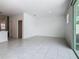 Open living space featuring neutral ceramic tile, access to kitchen, and sliding doors to outdoor area at 7685 Stone Creek Trl, Kissimmee, FL 34747