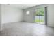 Open-plan living room featuring sliding glass doors to outdoor space and neutral ceramic tile flooring at 7685 Stone Creek Trl, Kissimmee, FL 34747
