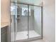 Glass enclosed shower with gray tiling and recessed shelves at 7685 Stone Creek Trl, Kissimmee, FL 34747