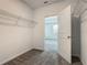 Walk-in closet with gray carpet and wire shelves, with door open to bedroom at 7685 Stone Creek Trl, Kissimmee, FL 34747