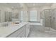 Bright bathroom with a double sink vanity, soaking tub, and glass-enclosed shower at 783 Ocean Course Ave, Davenport, FL 33896