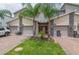 Beautiful townhome showcases a two-car garage, brick driveway, and a vibrant green lawn at 783 Ocean Course Ave, Davenport, FL 33896