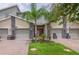 Charming townhome exterior features a red front door, two-car garage, and well-manicured lawn at 783 Ocean Course Ave, Davenport, FL 33896