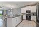 Open-concept kitchen with gray countertops, white cabinets, and stainless steel appliances at 783 Ocean Course Ave, Davenport, FL 33896