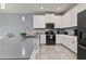 Contemporary kitchen featuring gray countertops, white cabinets, stainless appliances and pendant lighting at 783 Ocean Course Ave, Davenport, FL 33896