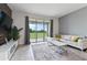 Bright living room with tile flooring, white couch and coffee table, and a sliding glass door to a balcony at 783 Ocean Course Ave, Davenport, FL 33896