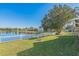 Scenic backyard view with a white picket fence overlooking a tranquil lake and lush green lawn at 7922 Elmstone Cir, Orlando, FL 32822