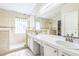 Bright bathroom with double vanity, large mirror and tiled glass-enclosed shower at 7922 Elmstone Cir, Orlando, FL 32822