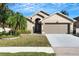 Charming home featuring a manicured lawn, arched entry, and a two-car garage at 7922 Elmstone Cir, Orlando, FL 32822