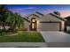 Charming home featuring a manicured lawn, arched entry, and a two-car garage at 7922 Elmstone Cir, Orlando, FL 32822