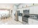 This kitchen offers stainless steel appliances, white cabinets, granite countertops, and tile floors at 7922 Elmstone Cir, Orlando, FL 32822