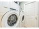 Laundry room with Whirlpool washer and dryer, featuring storage cabinets and a white door at 7922 Elmstone Cir, Orlando, FL 32822