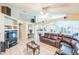 View of the expansive living room with vaulted ceilings, tile floors, built-in shelving, and a cozy leather sofa at 7922 Elmstone Cir, Orlando, FL 32822