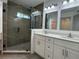 Bathroom with double vanity, modern lighting, and walk-in shower with glass door at 793 N Kentucky Ave, Umatilla, FL 32784